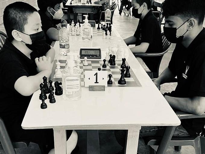 Junior players seated at chess boards during a school chess event.